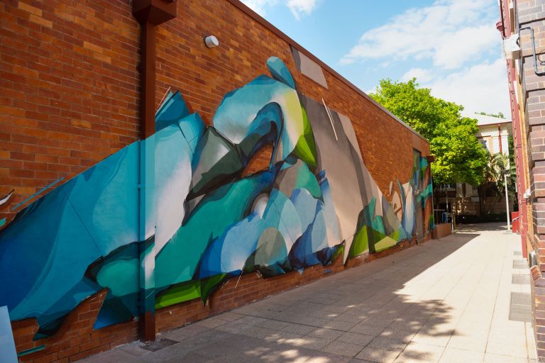 Green, Blue and Grey street art mural on a brick wall