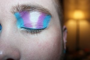 Person with eyeshadow. Colours in theme with the transgender flag.