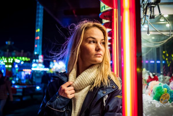 Woman leaning against neon light