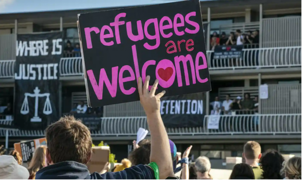 Protest sign reading: refugees are welcome